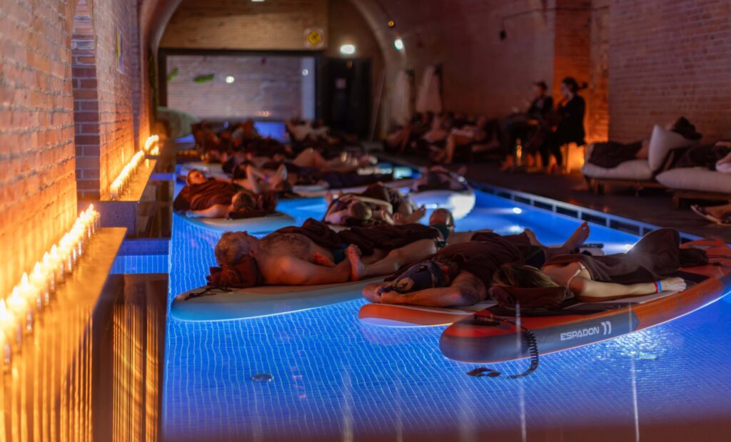 Water concert participants floating on SUP boards in the pool
